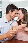 Happy loving young couple with wine glasses at home