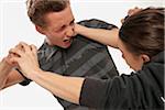 Close-up of two young men fighting, studio shot on white background