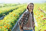 Summer on an organic farm. A young girl in a field of flowers.