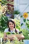 Summer on an organic farm. A girl holding a basket of fresh cucumbers.