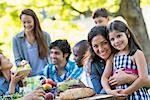 A summer party outdoors. Adults and children smiling and looking at the camera.