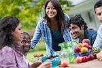 A summer party outdoors. Four people at a table.