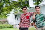 Two boys in a farmhouse garden in summer.