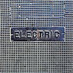 A utility cover made of metal, with the word Electric.