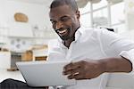 Business people. The office in summer. One person sitting comfortably in a quiet airy office environment. Using a digital tablet.