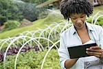An organic horticultural nursery and farm outside Woodstock. A woman holding a digital tablet.