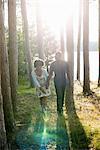 A happy couple in a shady spot in woodland in summer.