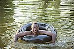 A boy floating in the water using a tyre swim float.