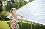 A child in the fresh open air on a sunny day, beside solar panels at a farm in New York State, USA.