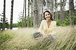 A woman in open countryside, by a mountain lake.