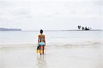 A young woman in shallow water with snorkelling gear on Samana Peninsula in the Dominican Republic.