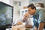 Two architects working on a green construction project, using computer technology. Scale model of a building. Computer design.