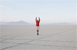 A man jumping in the air on the flat desert or playa or Black Rock Desert, Nevada.