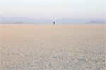 The figure of a man in the empty desert landscape of Black Rock desert, Nevada.