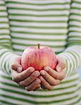 Detail of nine year old girl holding organic apple