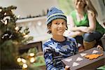 A boy with a Christmas present, gift wrapped in a box with recycled Christmas packaging.