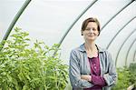 A woman working at an organic farm, in the greenhouse or polytunnel.