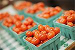 A farm stand. Green boxes of tomatoes.