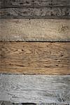 A heap of recycled reclaimed timber planks of wood. Environmentally responsible reclamation in a timber yard. Varieties of wood, with grain and colour details.