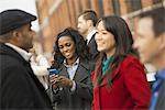 City life. A group of people on the go, keeping in contact, talking to each other. Men and women, gathering outdoors. Five people.