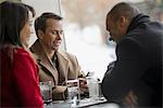 City life. A group of people on the go, using mobile phones, and talking to each other. In a coffee shop.