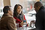 City life. A group of people on the go,using mobile phones, and talking to each other. In a coffee shop.