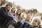 Five children on a farm. Boys and girls in warm jackets outdoors.