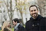 Group walking in urban park, man in front