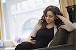 Woman relaxing at home using smartphone
