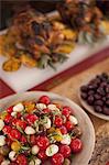 A buffet table laid out for a party. Organic food. Salads and a chicken dish.