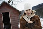 An organic farm in upstate New York, in winter. A woman holding a clutch of hen's eggs in her hands.