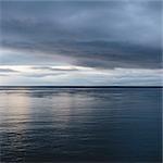 The sea and sky over Puget Sound in Washington, USA. The horizon with light cloud layers above.