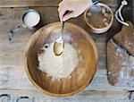 A domestic kitchen. A cook preparing a meal. A large bowl with oill and flour. Creating pastry.