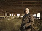 An Organic Farm in Winter in Cold Spring, New York State. A farmer in a livestock barn with sheep at lambing time.