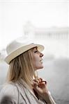 A woman with blonde hair wearing a cream panama hat.