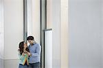 Urban Lifestyle. A young couple, man and woman side by side, looking at a mobile phone.