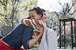 A New York city park in the spring. Sunshine and cherry blossom. A mother and son spending time together.