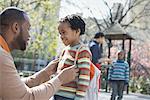 A New York city park in the spring. A family, parents and two boys spending time together.