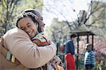 A New York city park in the spring. A family together. A father hugging his son.