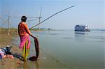 Woman with laundry and sukapha boat on the Hooghly River, part of Ganges River, West Bengal, India, Asia