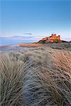 Evening sunlight illuminates Bamburgh Castle, Northumberland, England, United Kingdom, Europe