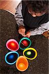 Overhead View of Boy using Coloring Cups to Dye Easter Eggs on Granite Kitchen Counter