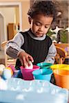 Boy using Coloring Cups to Dye Easter Eggs in Kitchen