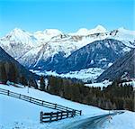 Winter mountain country landscape with road on slope (Austria).