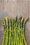 bunch of fresh green asparagus on old wood board, rustic style