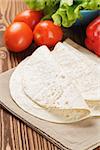 wheat tortillas with vegetables on old wooden table rustic style