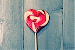 Photo of heart shaped lollipop on wooden background