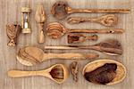 Olive wood kitchen utensil selection over papyrus background.