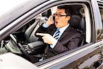 irate businessman talking with cell phone in the car