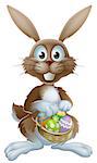 An Easter bunny rabbit holding a basket of decorated painted chocolate Easter eggs